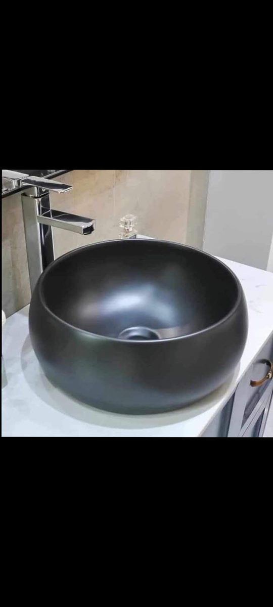 Modern black round sink on white countertop with chrome faucet installed by Sphapower Plumbing