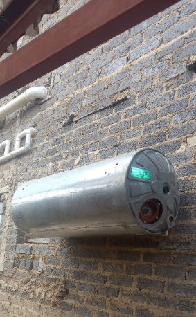 Cylindrical water heater geyser mounted on a brick wall by Sphapower Plumbing